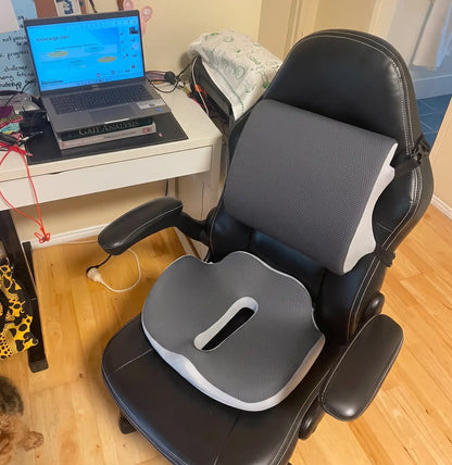 SitComfort seat cushion and lumbar support set up on a black leather office chair at a home desk