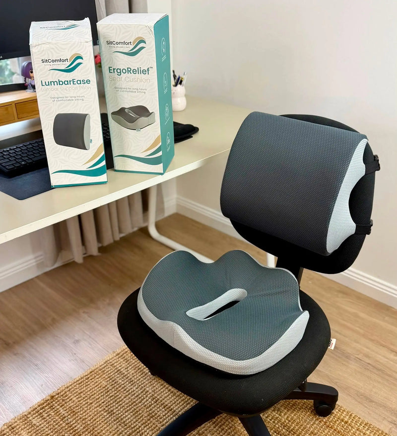 SitComfort ErgoRelief seat cushion and LumbarEase lumbar support fitted to an office chair at a home desk, with both product boxes on the desk